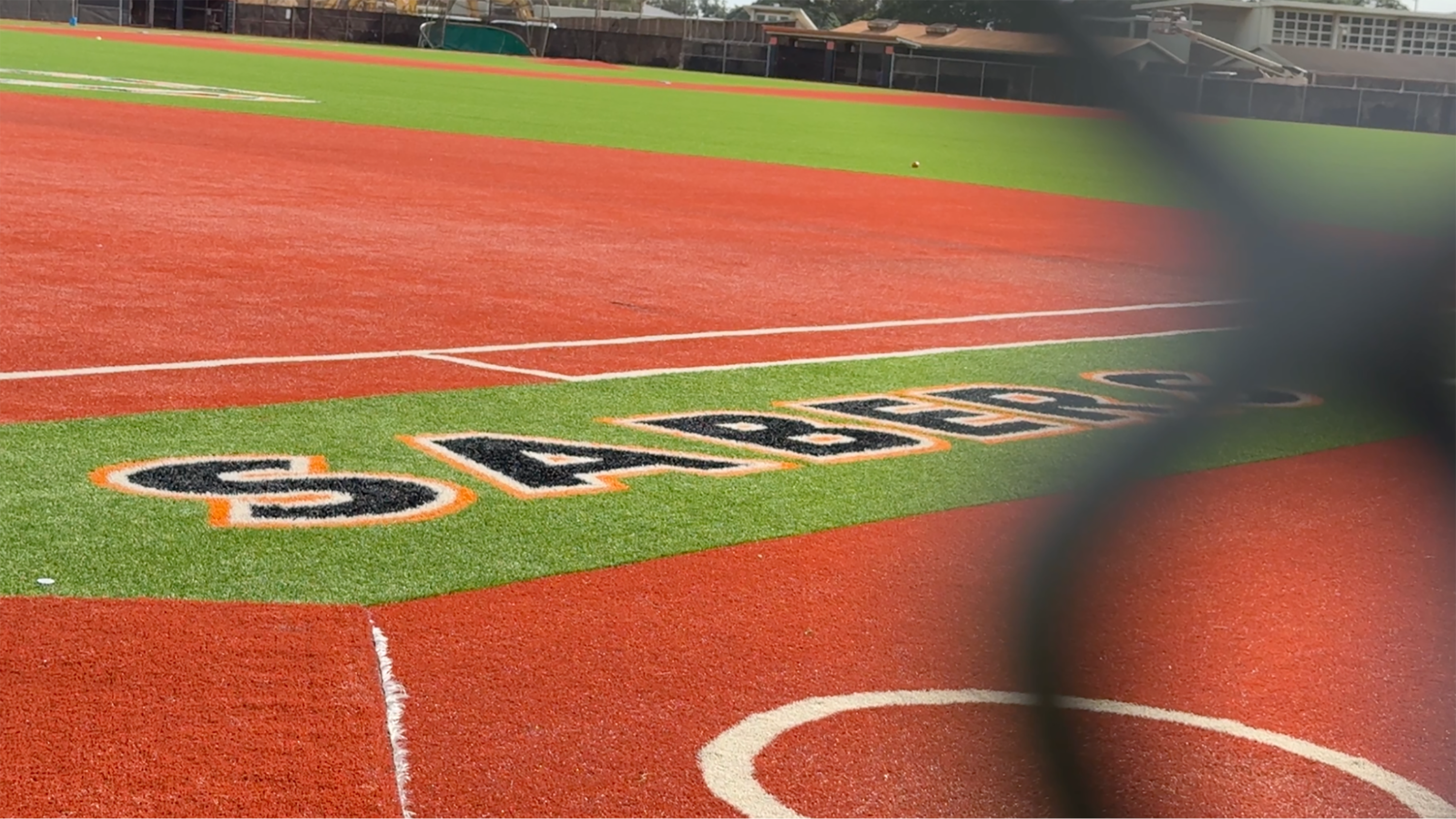 The Campbell High Sabers softball field is seen through a chainlink fence.